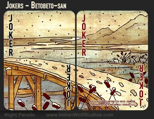 Two Joker cards from the Night Parade Fusion playing cards. A snow covered brigde spanning water with footprints in the snow, cattails in the forground, and mountains in the background.